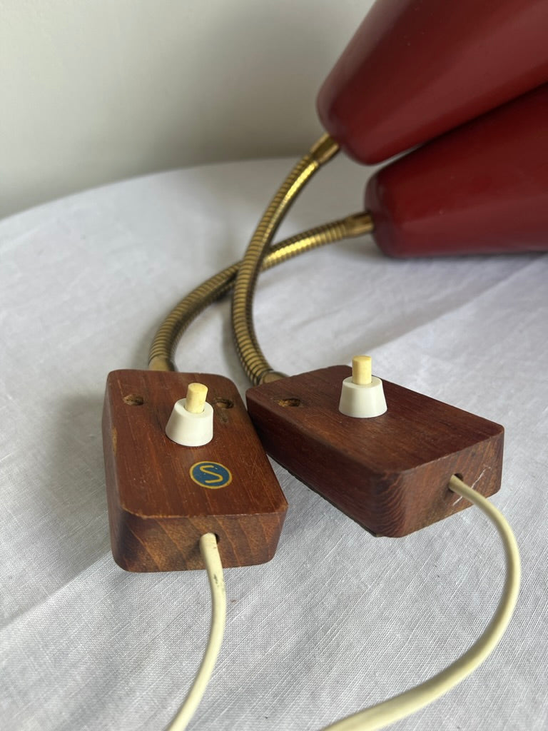 A pair of red and brass bendable matching bedside lights