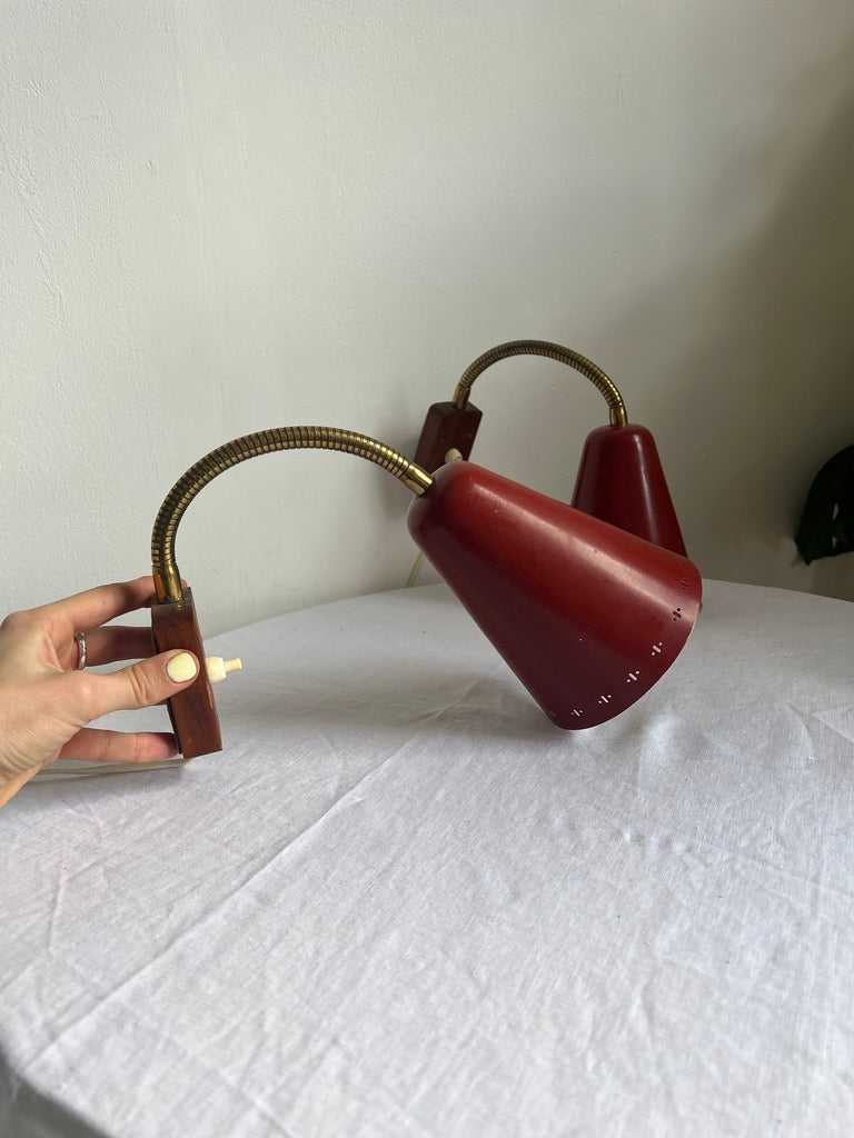 A pair of red and brass bendable matching bedside lights