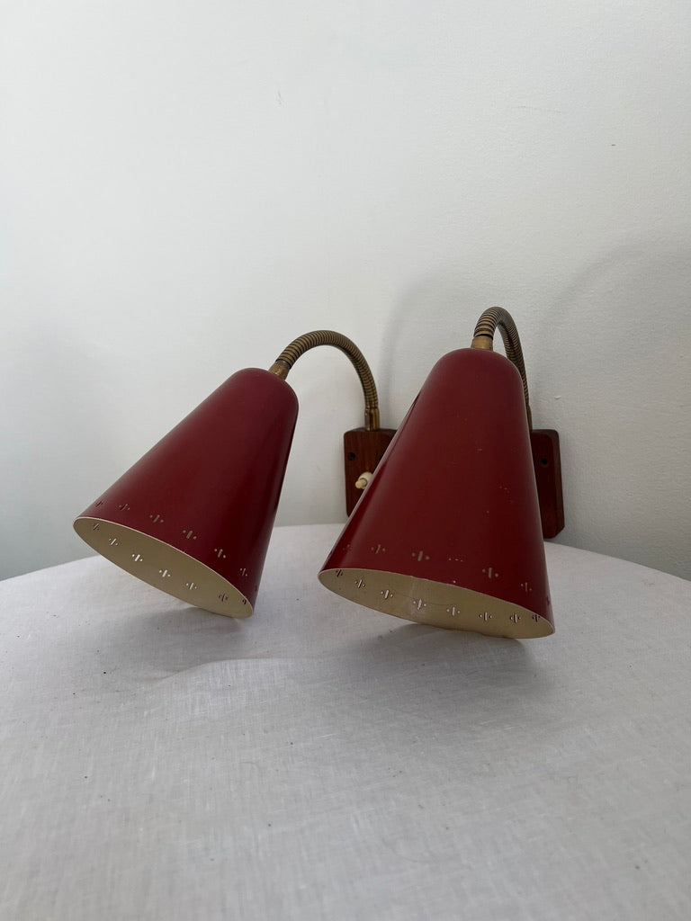 A pair of red and brass bendable matching bedside lights