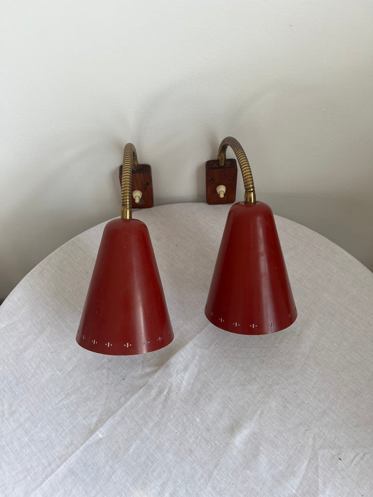 A pair of red and brass bendable matching bedside lights