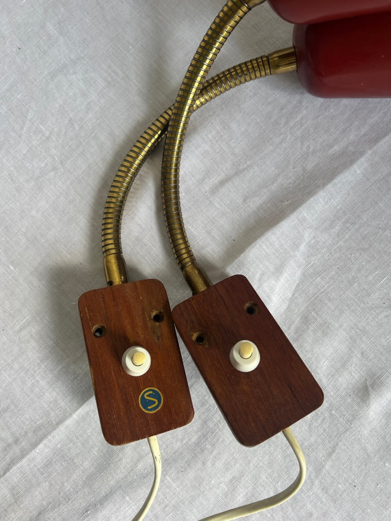 A pair of red and brass bendable matching bedside lights