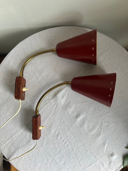 A pair of red and brass bendable matching bedside lights